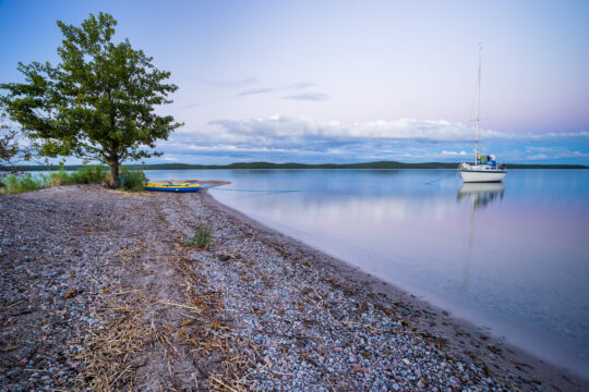 Purjevene Lietsaaren rannassa Päijänteen kansallispuistossa tyynenä iltana.