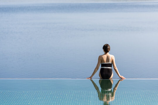 Lehmonkärki Resort Aisti Sauna & Spa nainen istumassa infinity poolin reunalla katse kohti Päjännettä