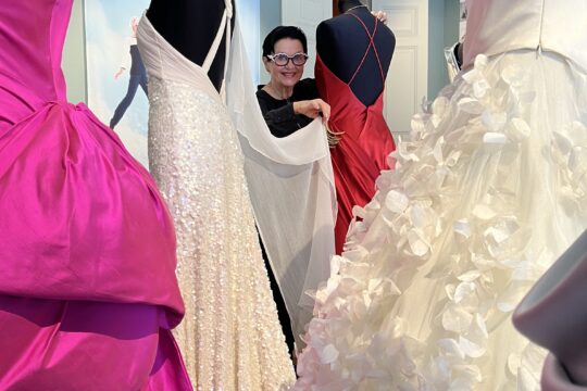 Ritva-Liisa Pohjalainen Heinolan taidemuseossa juhlapukujen keskellä